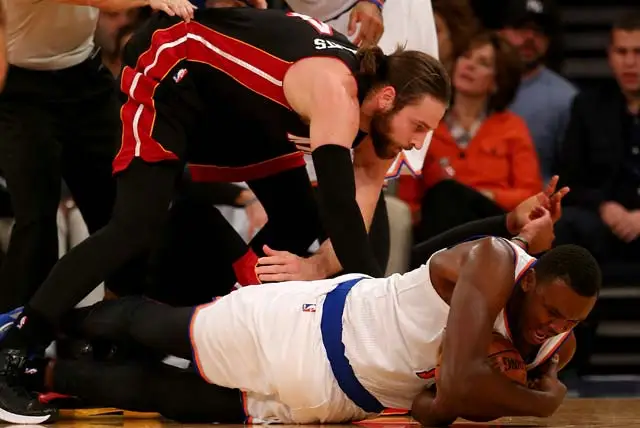 Samuel Dalembert of the New York Knicks and Josh McRoberts of the Miami Heat fight for the ball